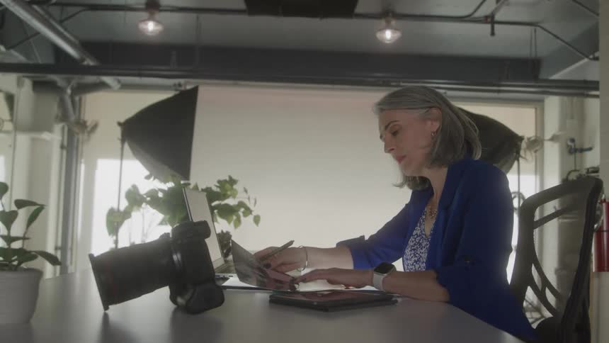 A young woman sitting on a couch in the living room wearing a virtual reality headset moving her hands and getting startled by something she saw