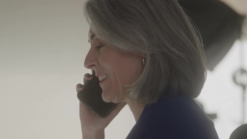 Woman smiles and laughs as she talks on the phone
