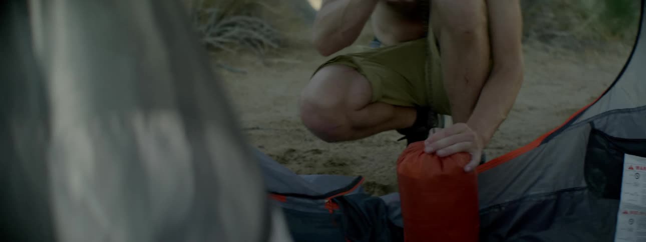A man is tying the strings on a bag
