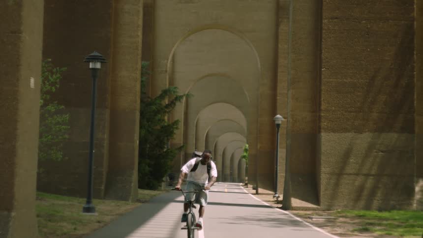 A man rides his bike past the camera