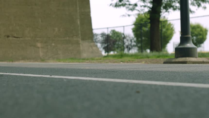 Vehicle moves along a road near a building on a summer day
