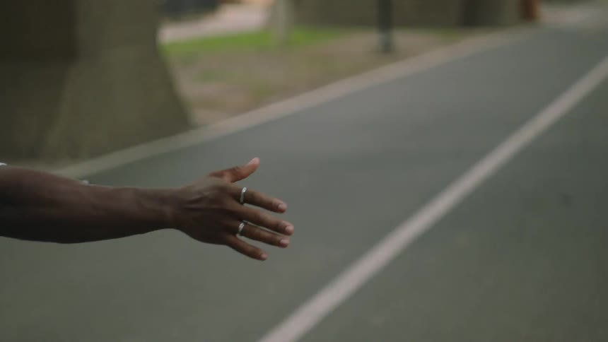 A man is riding a bicycle on a road with his hands off the handles