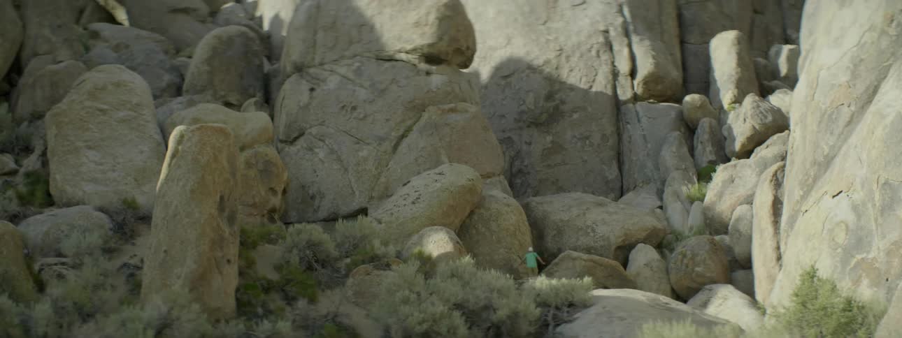 A hiker walks towards a rocky cliffside