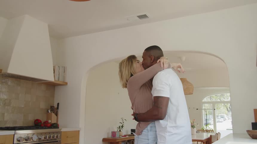 Happy couple dancing hugging and kissing in thier kitchen