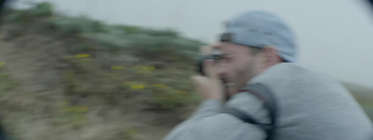 A man is taking photographs on a foggy trail