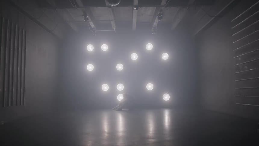 A dark studio shows flashing circular lights hovering in a loose pattern