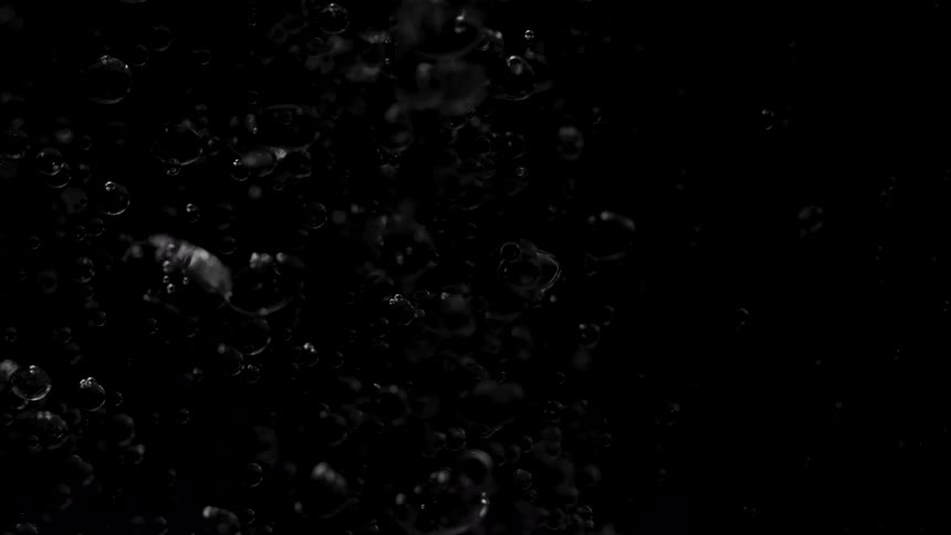 The bubbles are slowly rising in the dark water