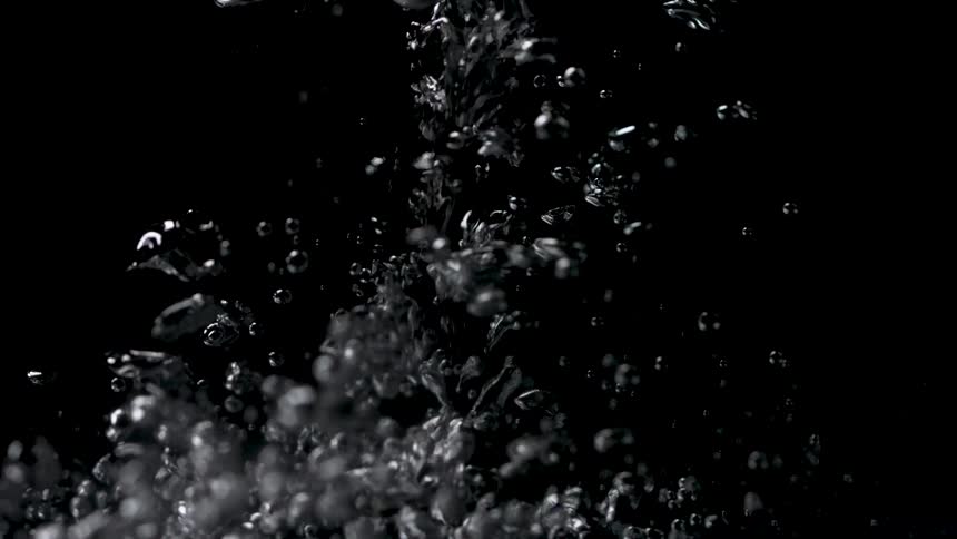 A clear liquid is poured causing submerged bubbles to form