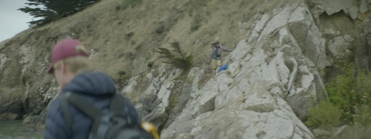 Hikers stand on a rocky mountainside
