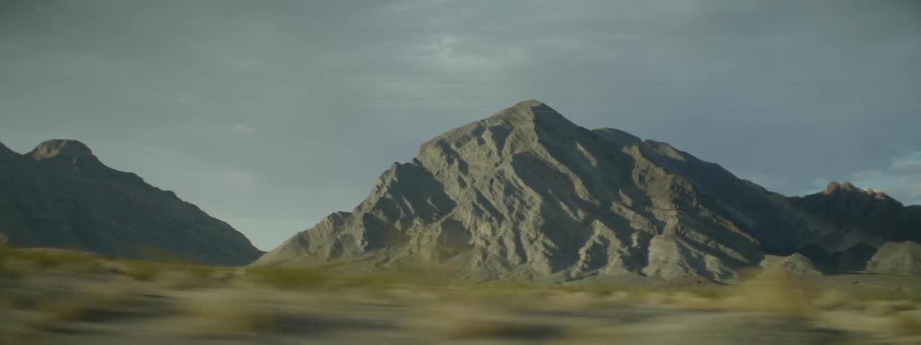 A long field leads to a mountain