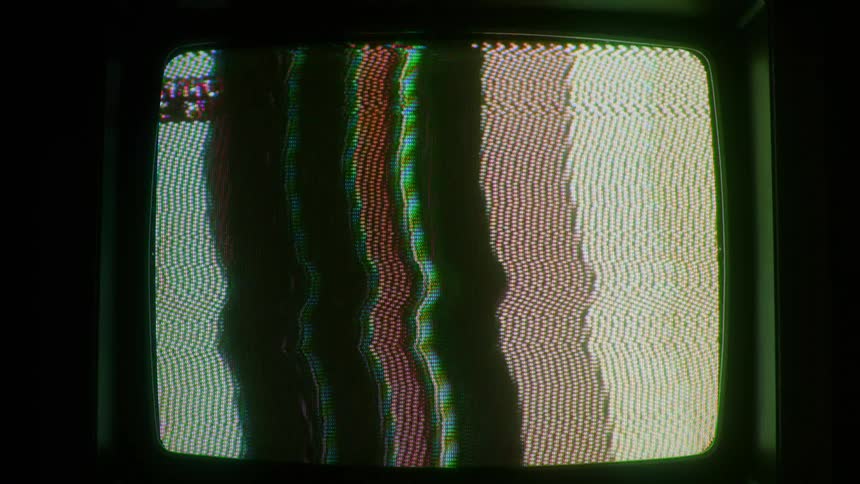 Television in a dark room with colored static moving on the screen