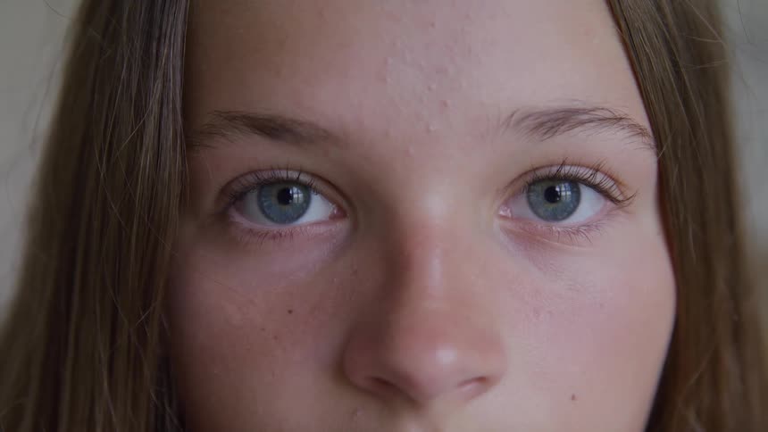 A young female opens her eyes and stares directly ahead