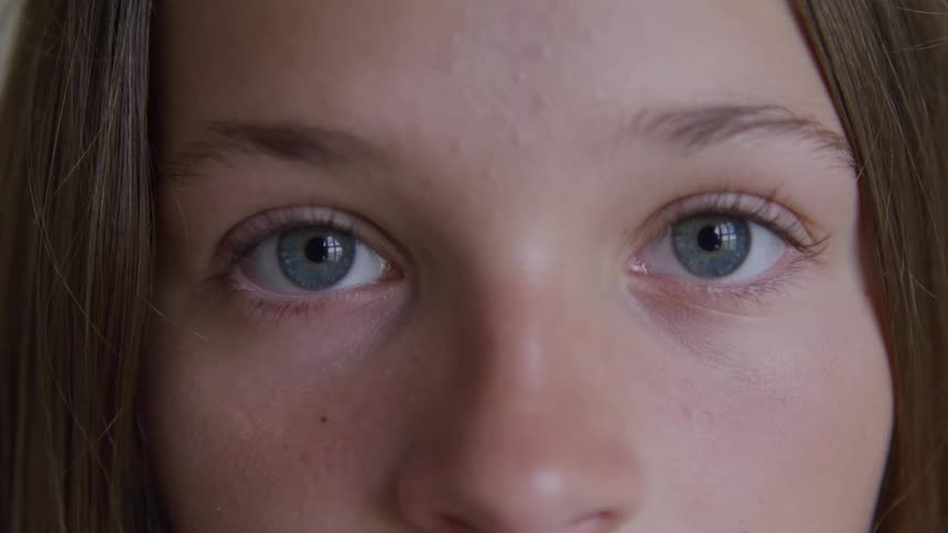 Young woman opens her eyes and stares