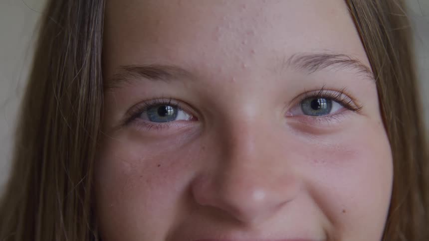 A teen girl blinks and smiles