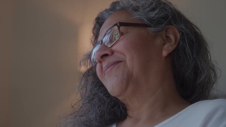 A female smiles as she looks around in a room