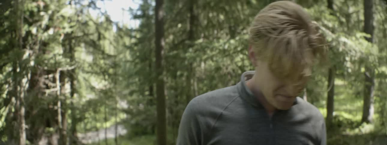 Blonde man in the forest walking away