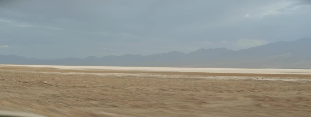 A vehicle drives through a desert