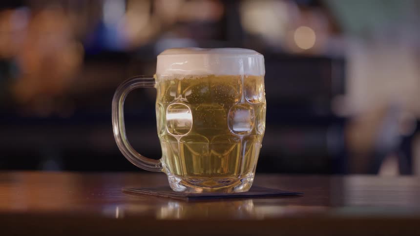 A person places down a mug of beer