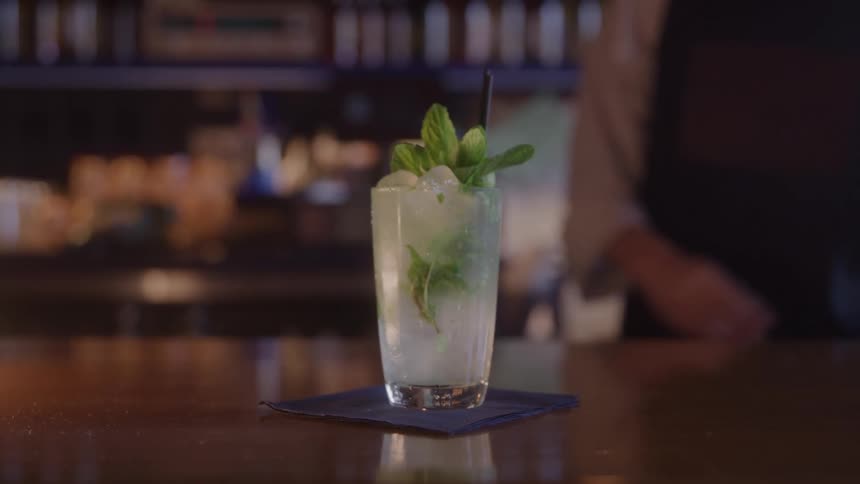 Bartender setting a cocktail down on the counter top