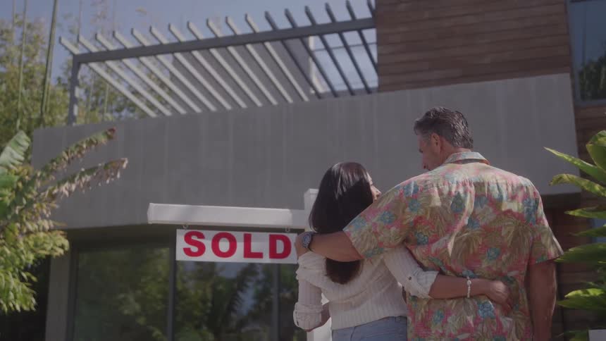 The couple hug in front of their new home