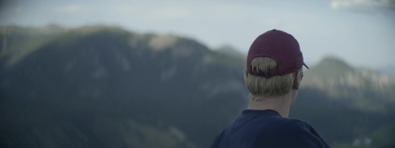 A man is looking out over a view of a mountain