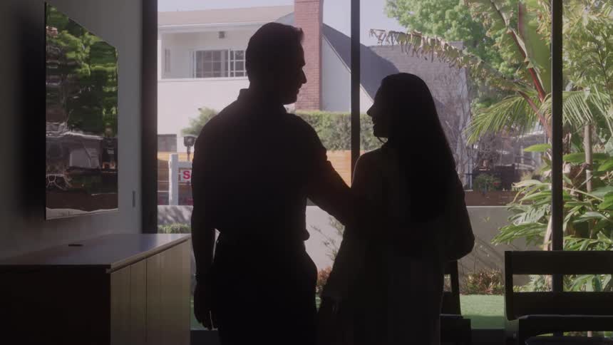 The man and woman hug in their home