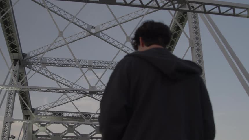 The teenager walks on the bridge