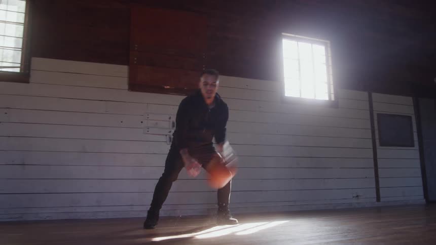 The man dribbles the basketball on the court
