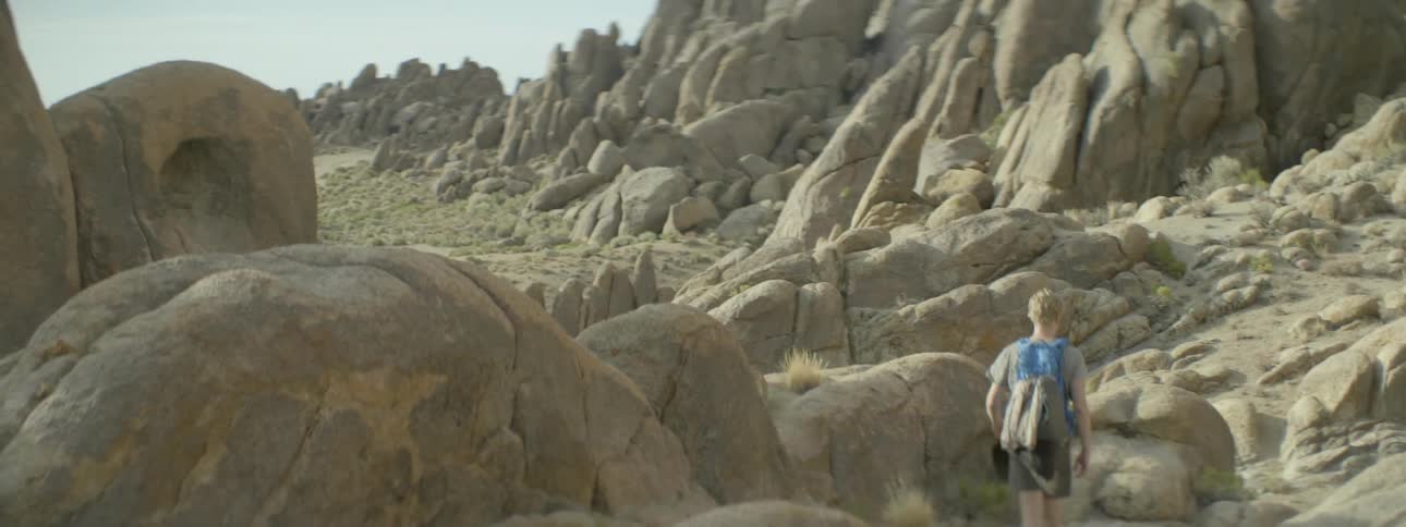 Teenager walking over rocky landscape