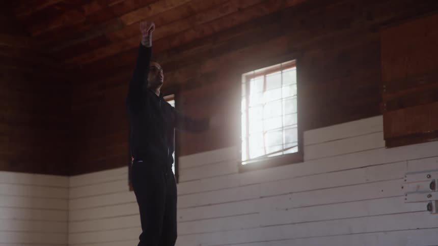 A man dribbles a basketball and shoots it in the air