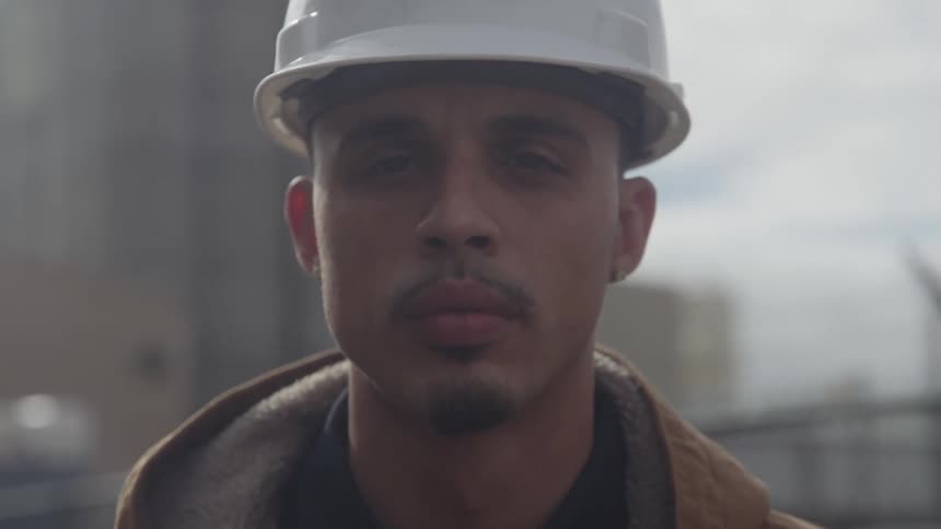 Close up portrait of a young male construction worker standing outdoors during daytime