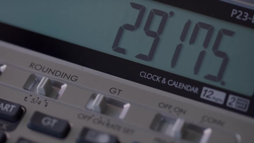 A close view of a digital calculator screen shows a sequence of numbers and symbols appearing and disappearing in what appears to be a time lapse scene
