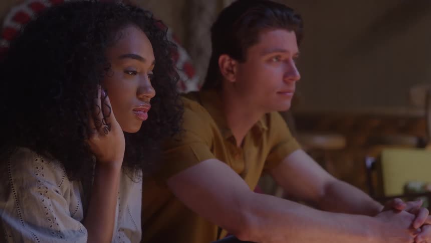 The man and woman are watching something together