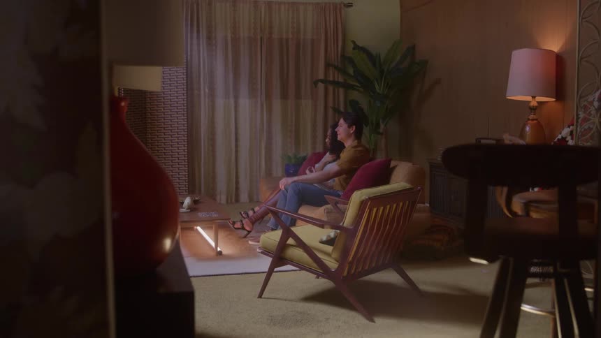 Couple sits together on a couch in a cozy living room