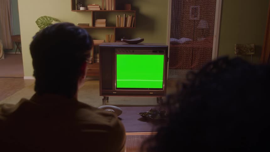 Man and woman sitting in the living room watch television