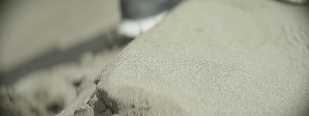 A person walks over some sand
