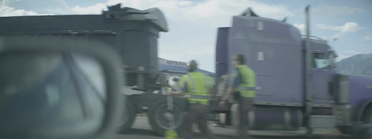 A vehicle passes by a large trailer