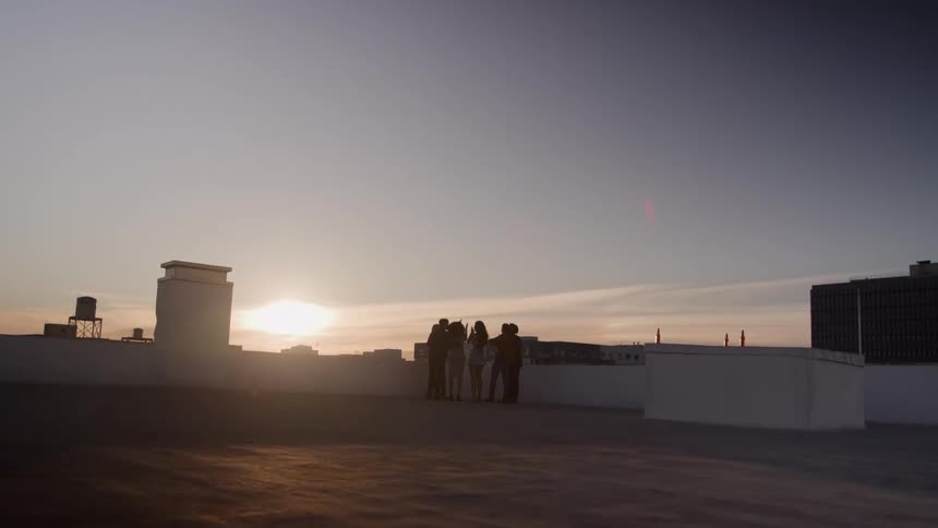 Friends walk to the edge of the roof and cheer