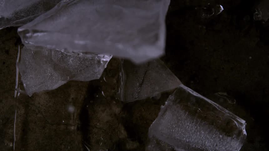 A piece of ice shatters into several fragments as it hits the floor