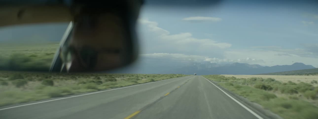 A man drives a car on a rural road
