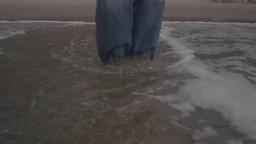 A person stands in the shallow water