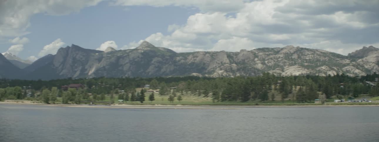 Across the lake is a mountain and people walking around