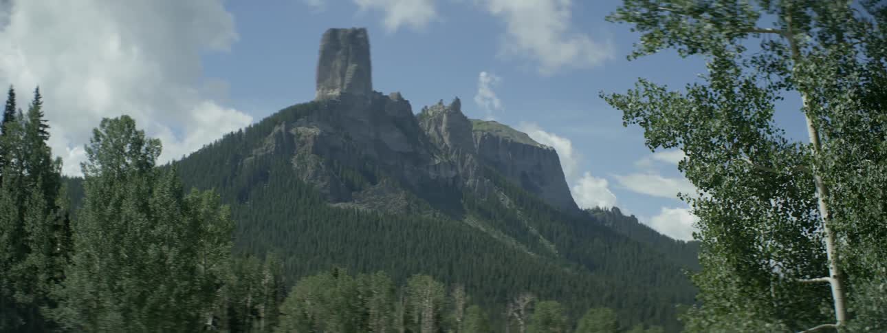 A rocky mountain peak is shown in the distance