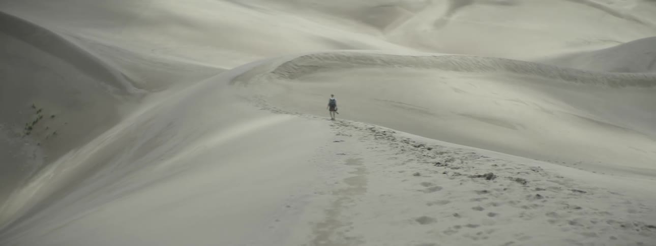 Person walking on sand dunes in the desert