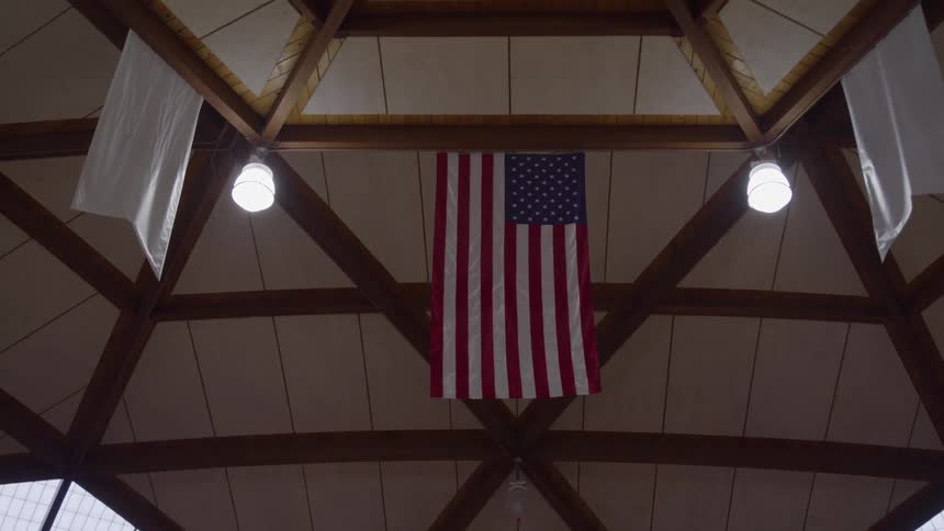 An american flag is hanging from the ceiling of the auditorium