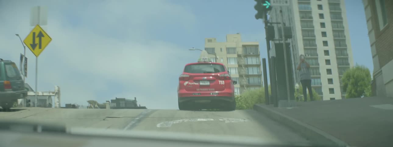 Cars drive on a city street