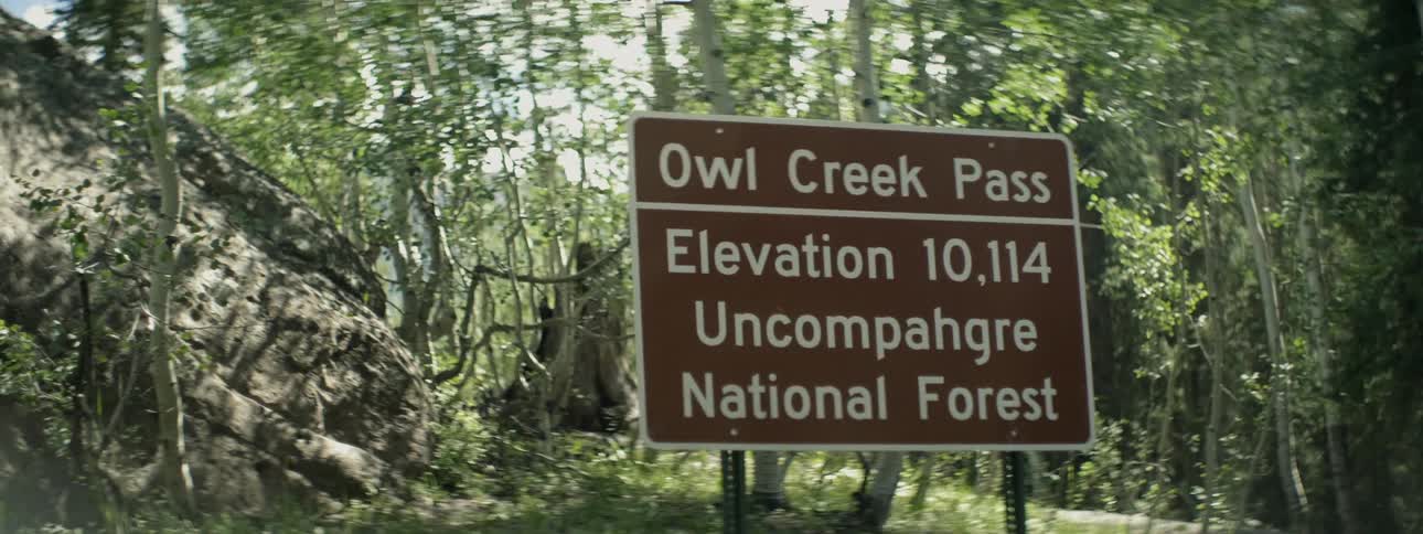 A sign is before a creek pass
