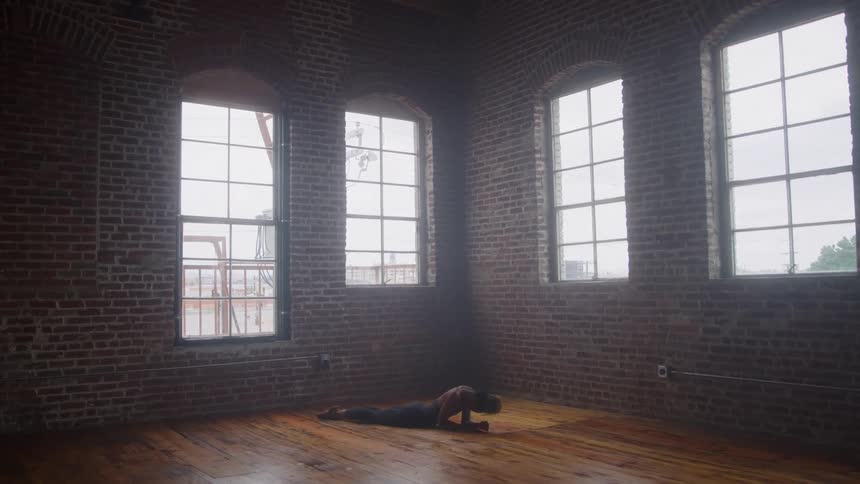 The woman is doing yoga in the large room
