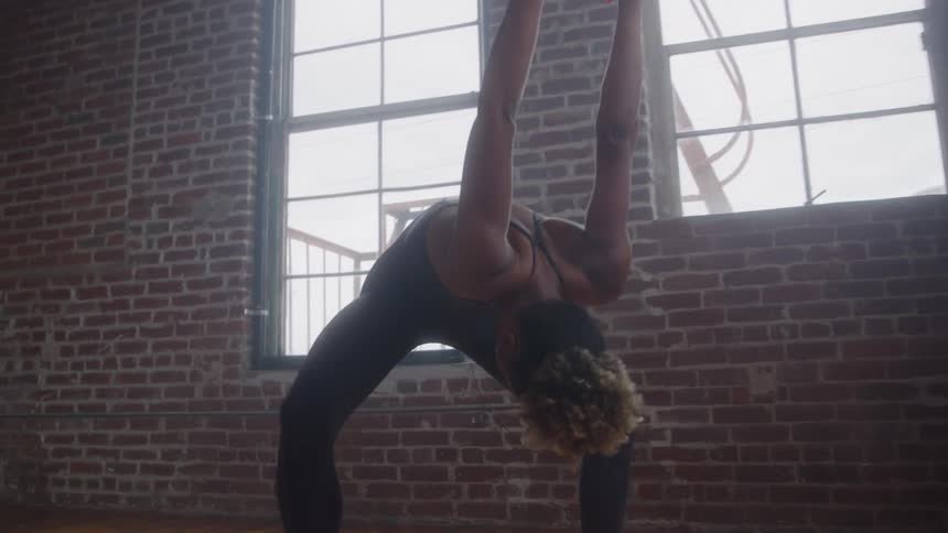 The woman is stretching her arms behind her back