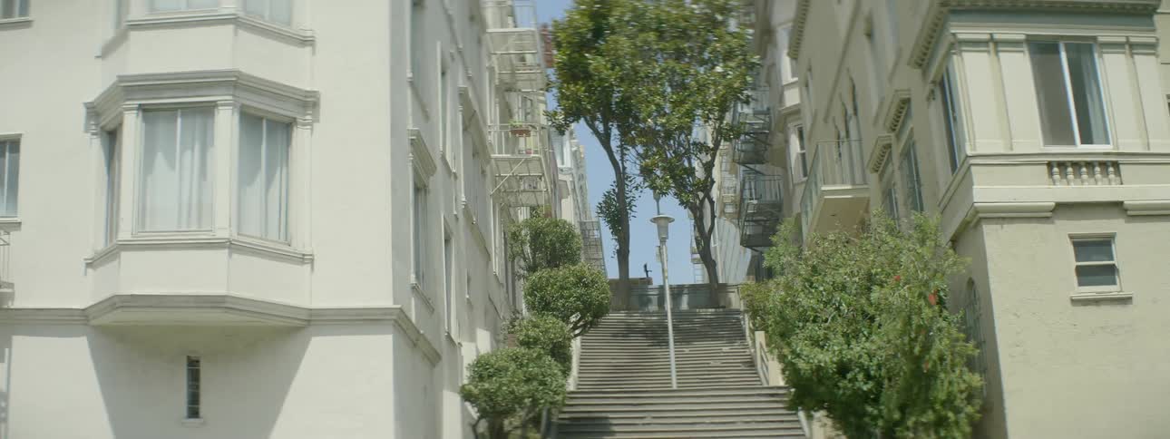 Stairway in between residential buildings in city on sunny day